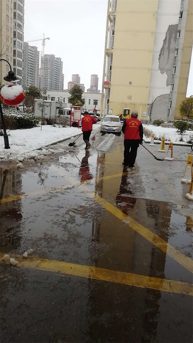 志愿者帮忙清扫小区路面积雪
